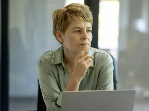 Woman looking pensively near her computer.