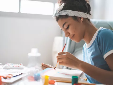 Young Adult Girl Painting on Canvas