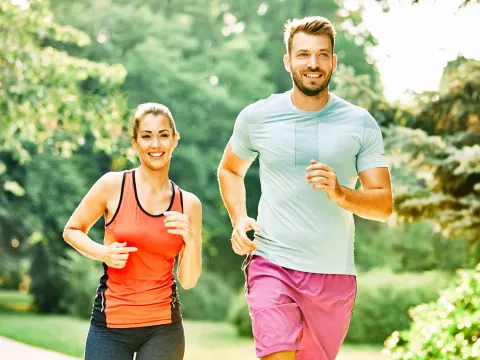 A young man and woman running.