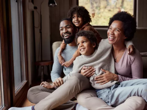 A happy African-American family looking out the window