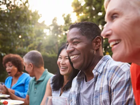 Friends sitting outdoors at a table during a dinner party.