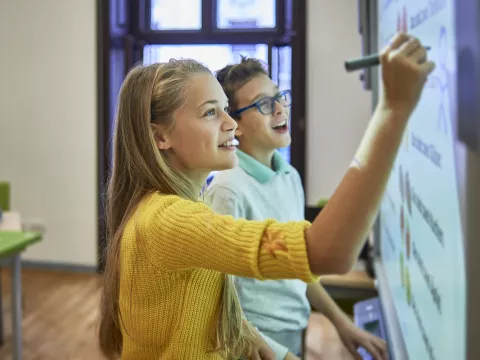 Two Middle School Kids Writing on Board