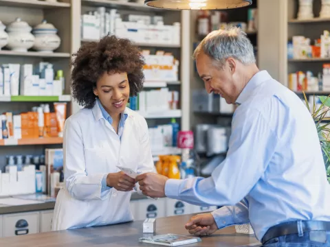 Pharmacist helping customer with filling prescription.