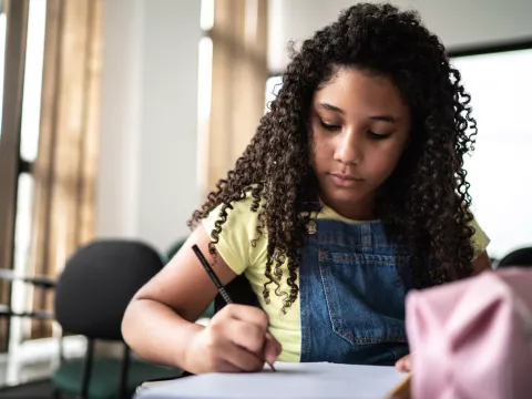 African American Girl Writing in Notebook