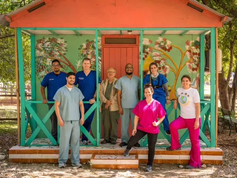 physicians in front of a decorative house