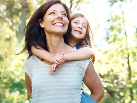Mother holding daughter from behind