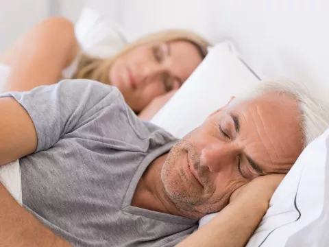 Mature couple sleeping on their bed