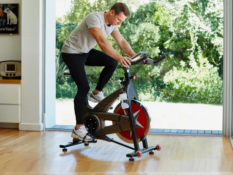 A man riding an exercise bike at home.