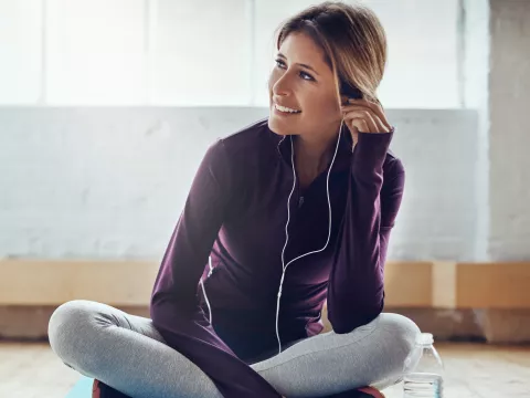 A woman wearing headphones and exercise clothes.