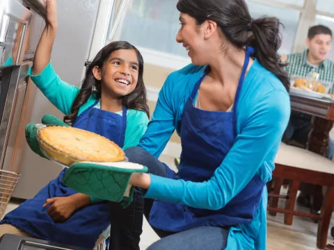 A family bakes a pie together.