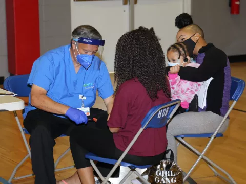 Dr. de Ramos doing clinical care on a child