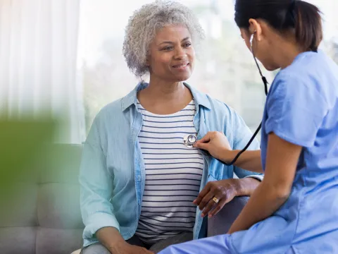 Female Doctor Listening to Woman's Heart