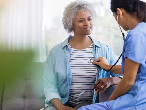 Female Doctor Listening to Woman's Heart