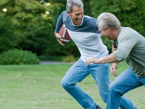 Senior men playing backyard football.