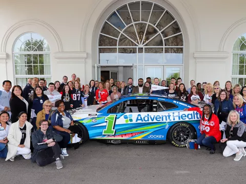 People Taking Picture in Front of Building With UChicago Medicine AdventHealth Car