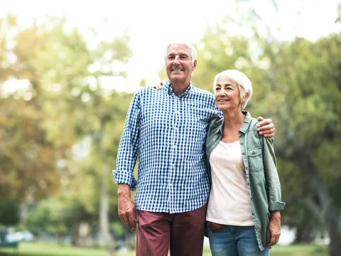 A man and woman embracing in the outdoors.