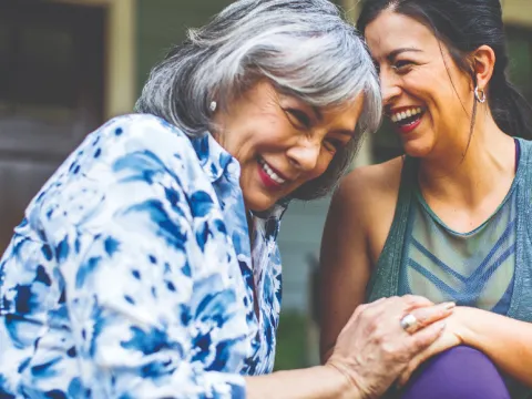 Two women holding hands and laughing.