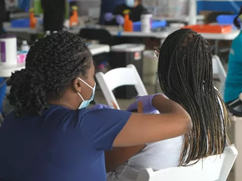 A nurse administers a vaccine to a patient at a community vaccination event