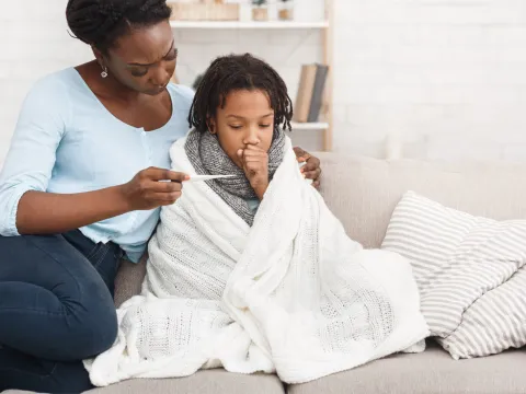 A mother taking her sick child's temperature 