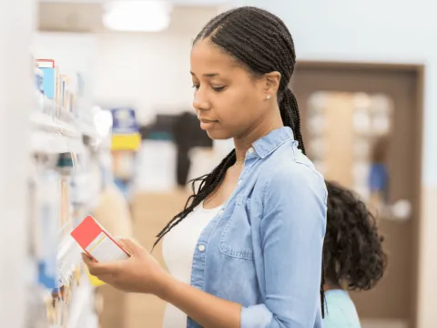 Woman looking at a product at a pharmacy.