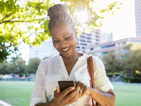 Woman using her phone while at a park.