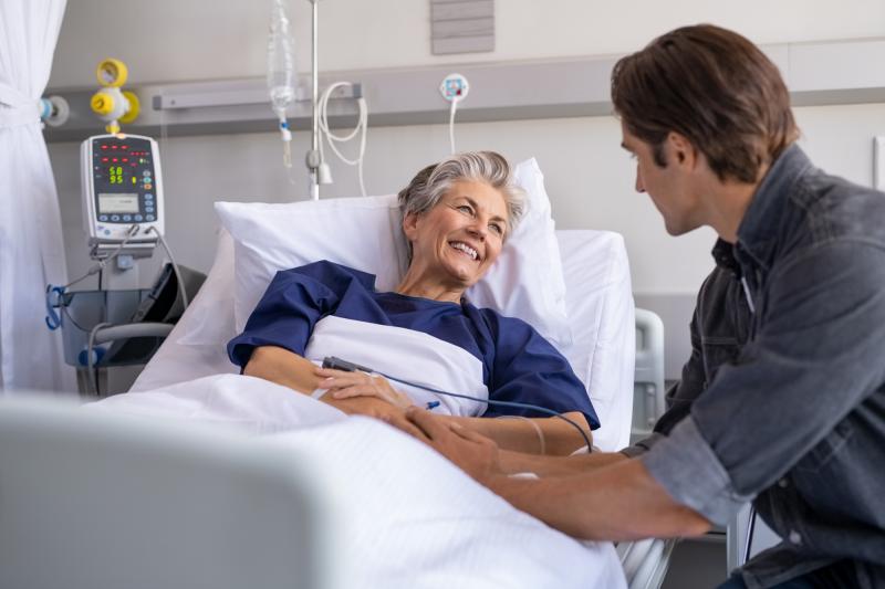 Son visiting sick old mother in hospital