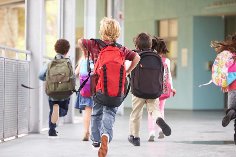 Kids Running to Class with Their Backpacks on.
