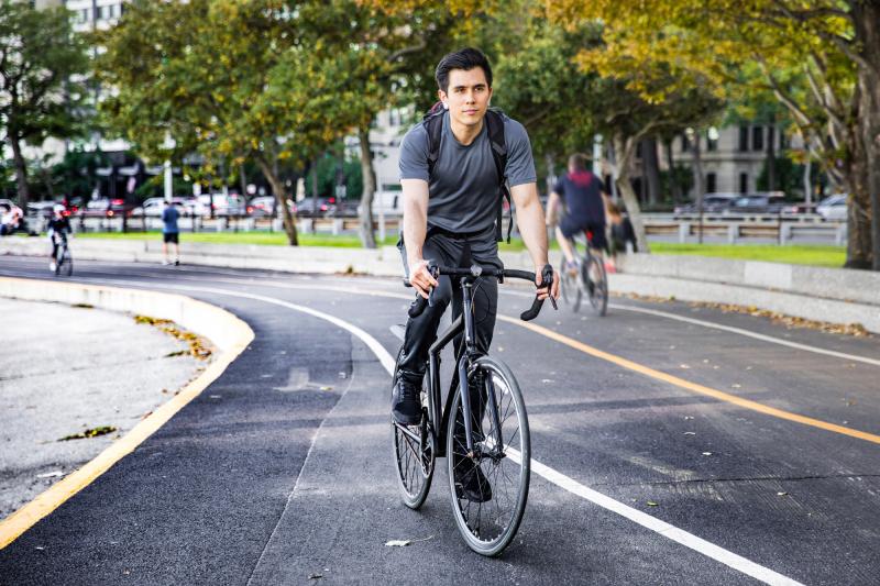 Happy young man cycling in the city, commuting to work in Chicago