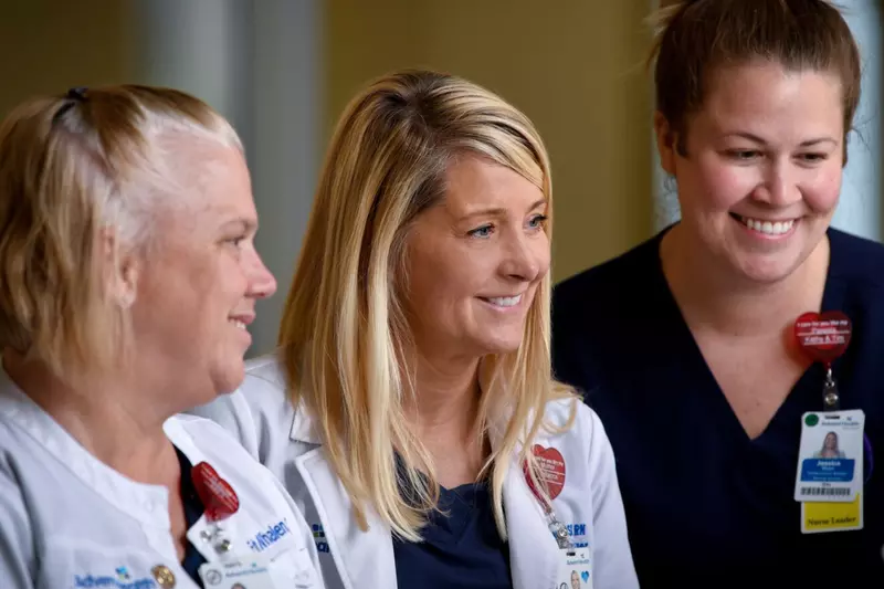 Three Health Care Providers Smile as They Interact on the Job