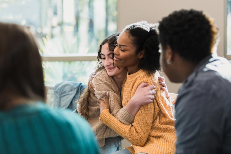 Two Girls Comforting Each Other at Group Discussion