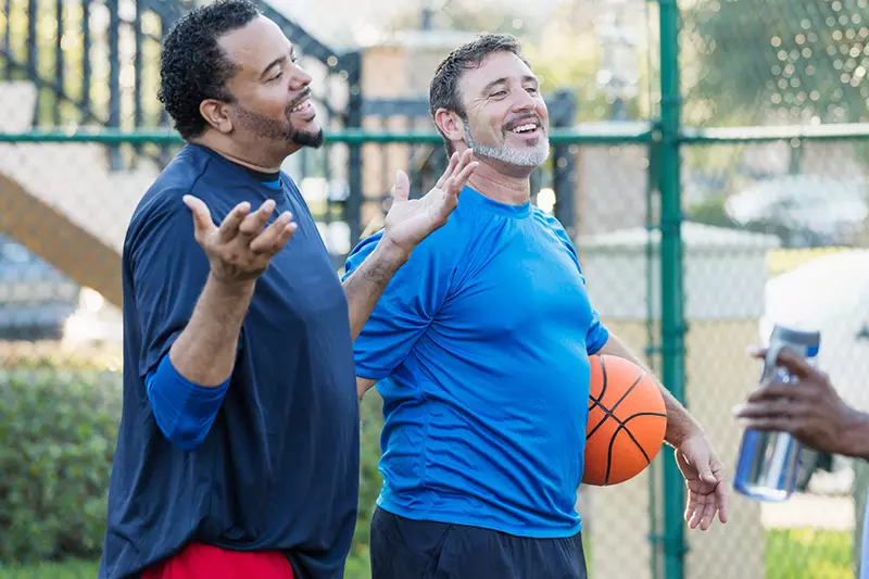 Group of men staying healthy playing basketball
