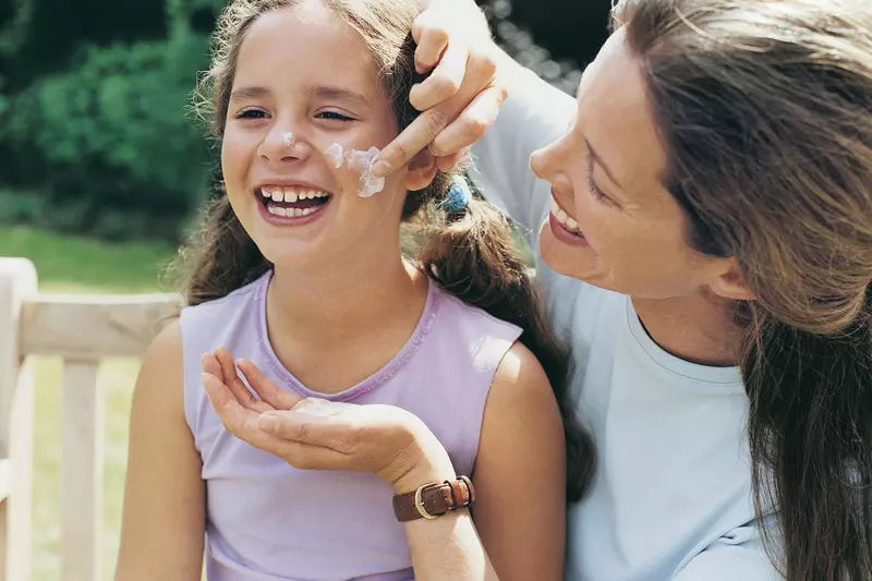 Mom applying sunscreen to daughter
