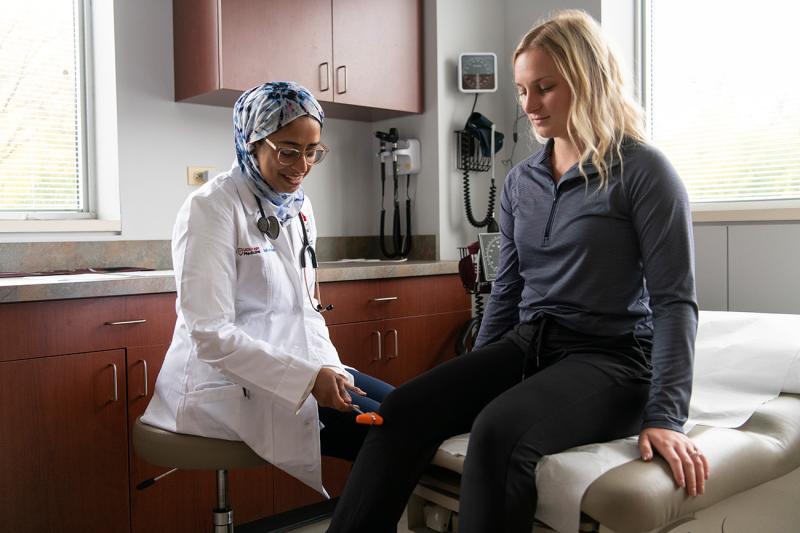 Doctor with patient checking knee functionality