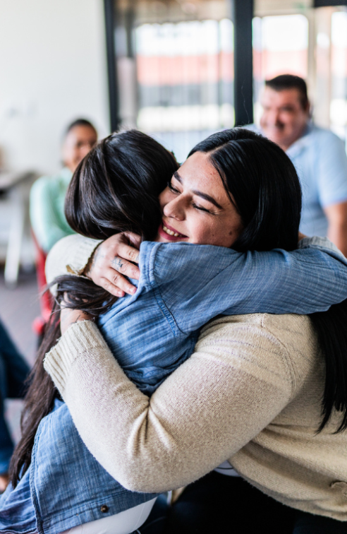 Two People Embrace at a Spiritual Meeting