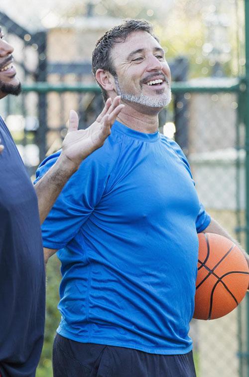 Group of men staying healthy playing basketball
