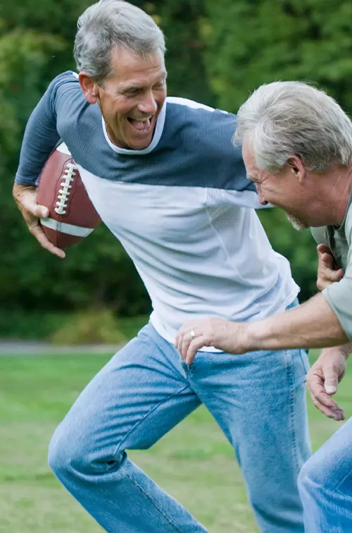 Senior men playing backyard football.