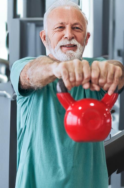 Older Man Holding Dumbell at the Gym
