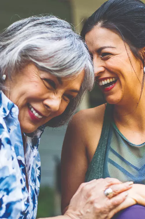 Two women holding hands and laughing.