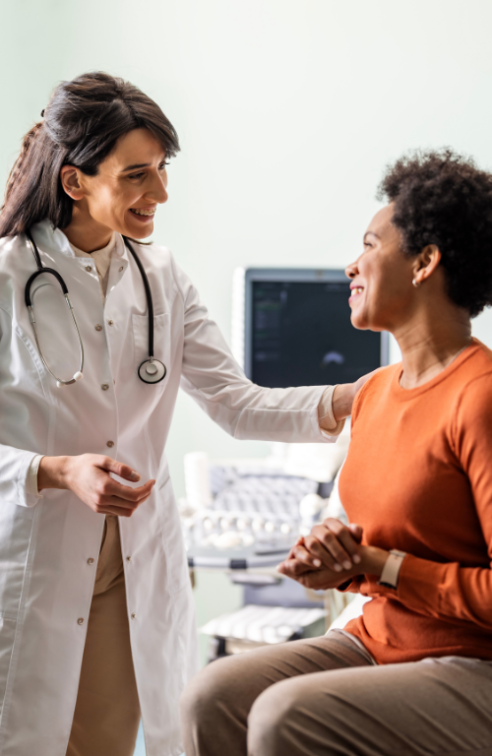 A woman talking with her doctor in an exam in room.