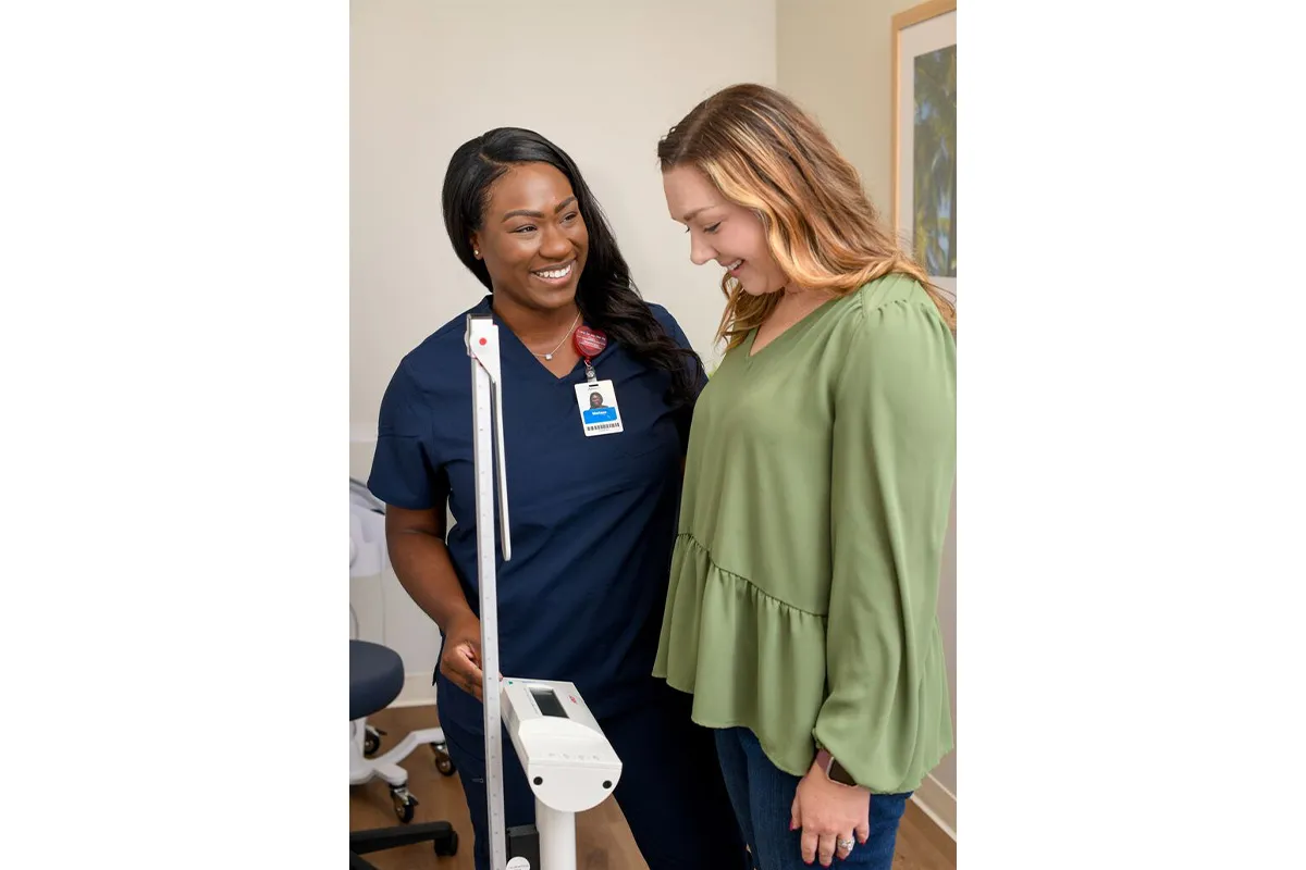 Nurse weighing patient.