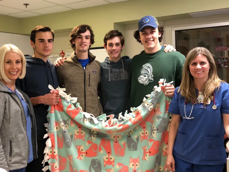 UCMAH Hinsdale Junior Board group of students with nurses holding blanket