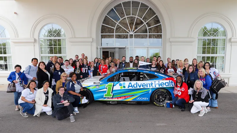 People Taking Picture in Front of Building With UChicago Medicine AdventHealth Car